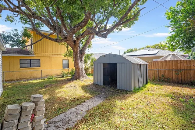 a view of a yard with wooden fence and a large tree