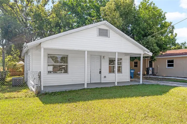 a view of a house with a yard and porch