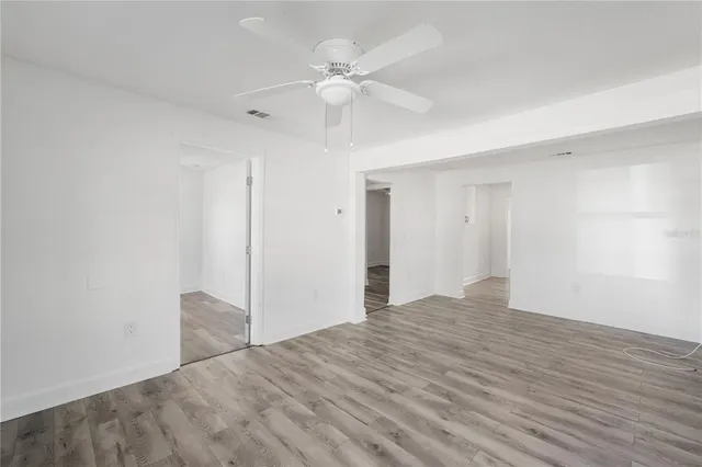 a view of an empty room with wooden floor