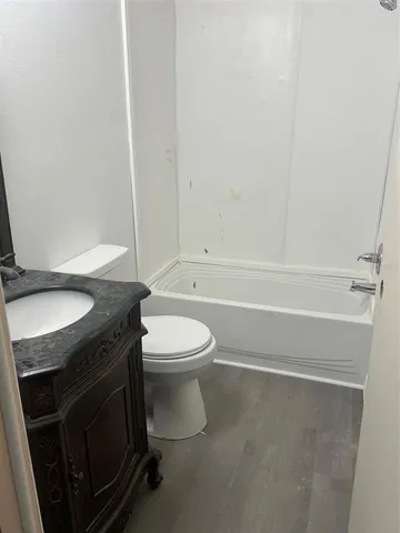 a bathroom with a granite countertop toilet sink and mirror