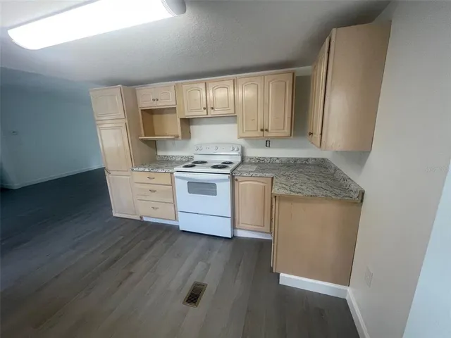 a kitchen with stainless steel appliances granite countertop a stove a sink and a refrigerator