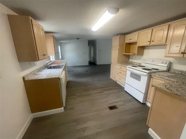 a kitchen with stainless steel appliances granite countertop a stove a sink and a microwave