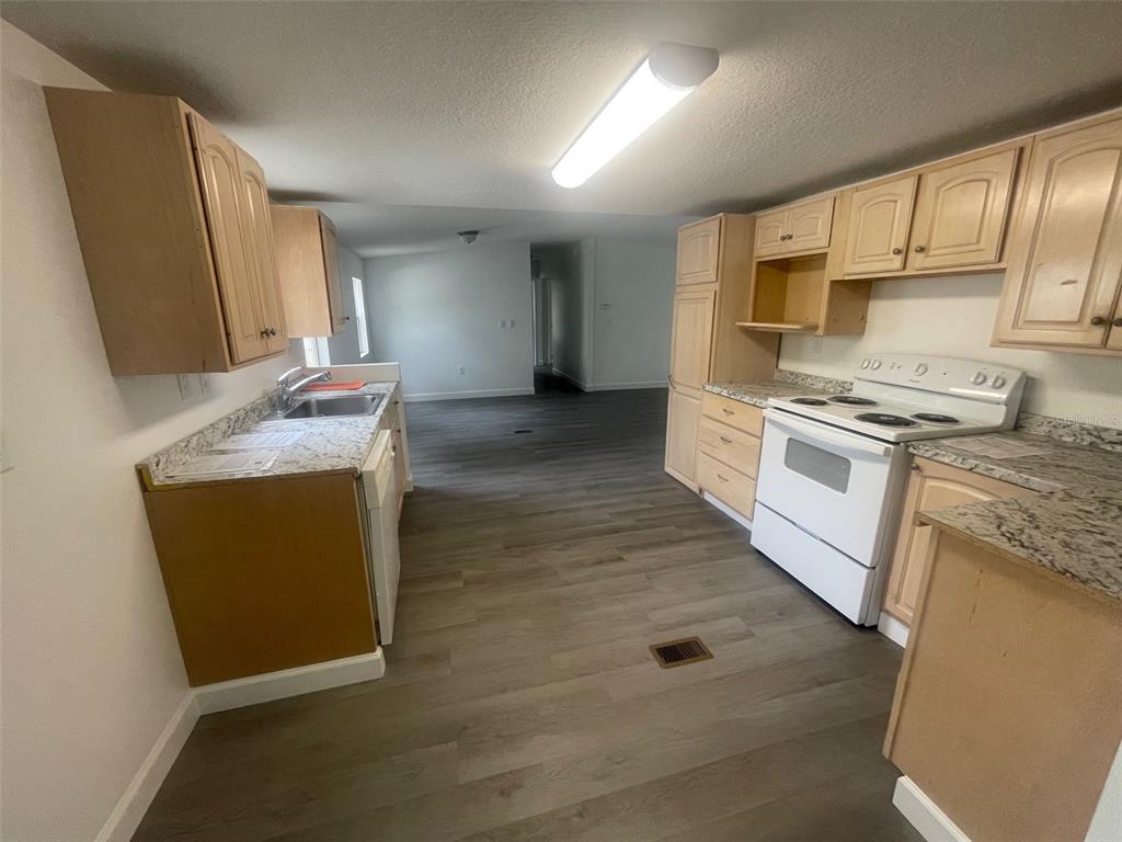 1001 Northeast 77th Street, Unit 3 Ocala, FL 34479 - Photo 5 of 20 a kitchen with stainless steel appliances granite countertop a stove a sink and a microwave