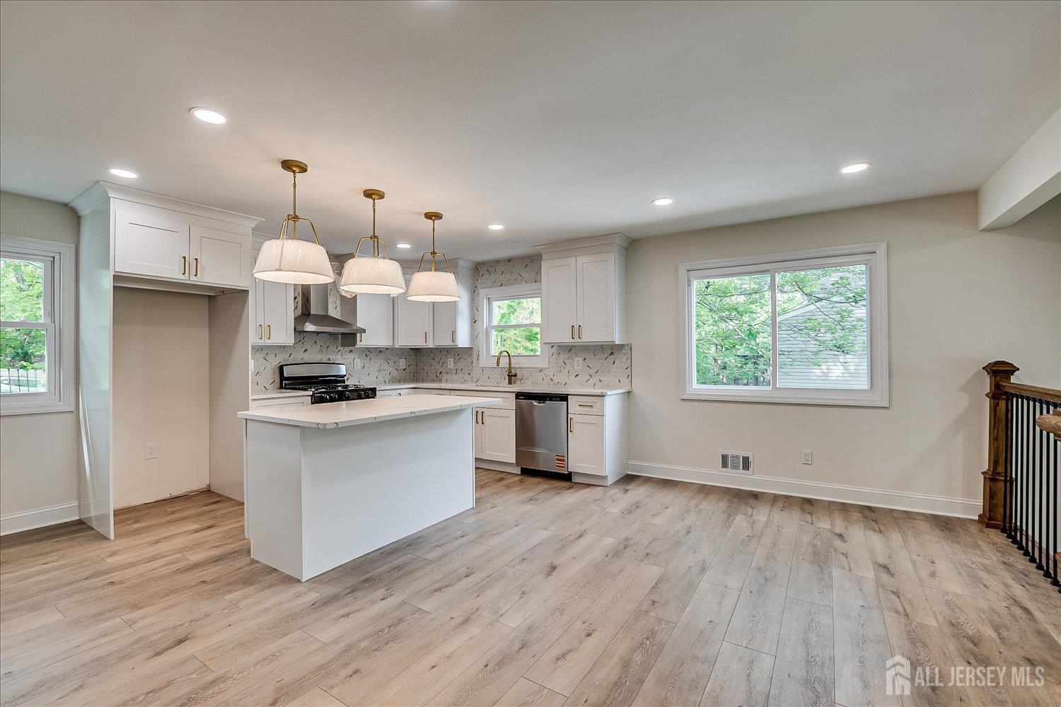 21 Lydia Lane Edison, NJ 08817 - Photo 20 of 49 a large kitchen with stainless steel appliances kitchen island granite countertop a large stove a sink dishwasher and a refrigerator with wooden floor