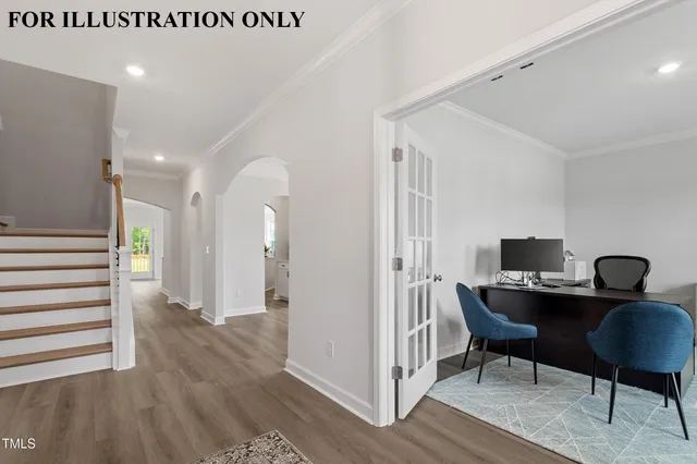a view of an empty room with wooden floor and kitchen