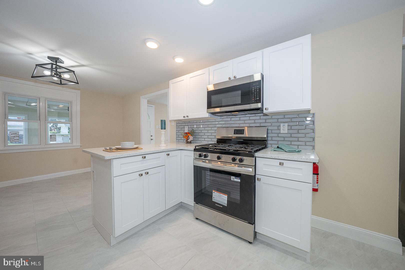 632 Merion Avenue Upper Darby, PA 19082 - Photo 31 of 84 a kitchen with stainless steel appliances granite countertop white cabinets a sink a stove and a microwave