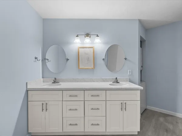 a bathroom with a double vanity sink and a mirror