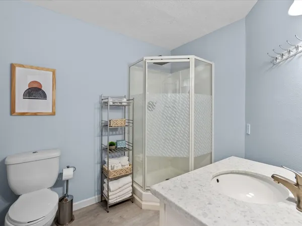 a bathroom with a granite countertop toilet a sink and mirror