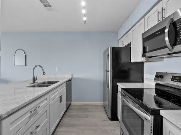 a kitchen with stainless steel appliances granite countertop a sink stove and refrigerator