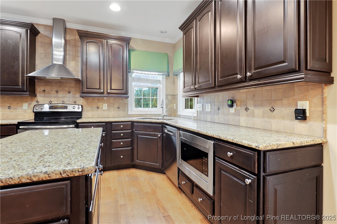 7124 Holmfield Road Fayetteville, NC 28306 - Photo 16 of 45 a kitchen with granite countertop stainless steel appliances a sink stove and cabinets