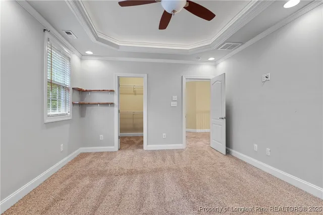 an empty room with wooden floor ceiling fan and window