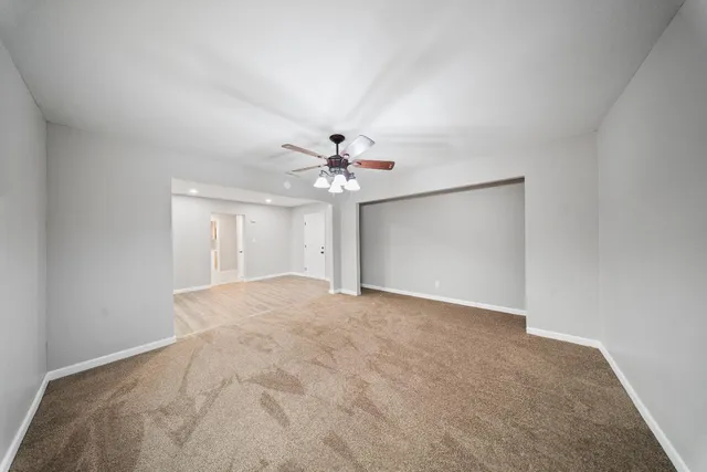 a view of an empty room with a ceiling fan