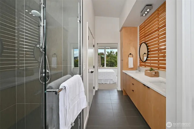 a bathroom with a double vanity sink a mirror and a shower