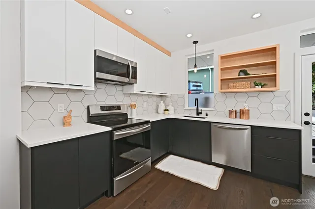 a kitchen with stainless steel appliances a sink dishwasher a stove microwave and cabinets