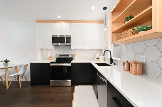 a kitchen with granite countertop a stove a sink and a microwave