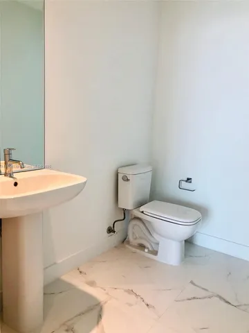 a white toilet sitting next to a bathroom sink