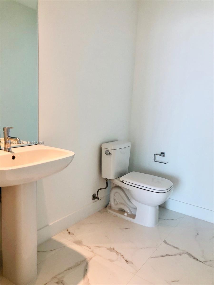 2900 Northeast 7th Avenue, Unit 2404 Miami, FL 33137 - Photo 4 of 42 a white toilet sitting next to a bathroom sink