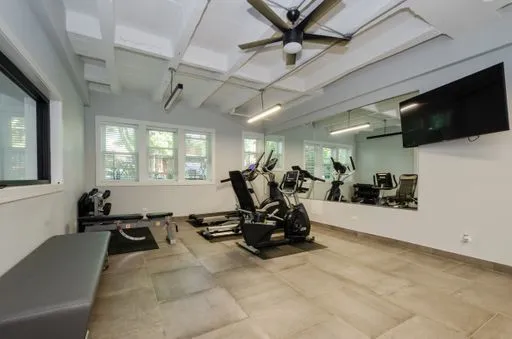 a living room with furniture gym equipment and a flat screen tv