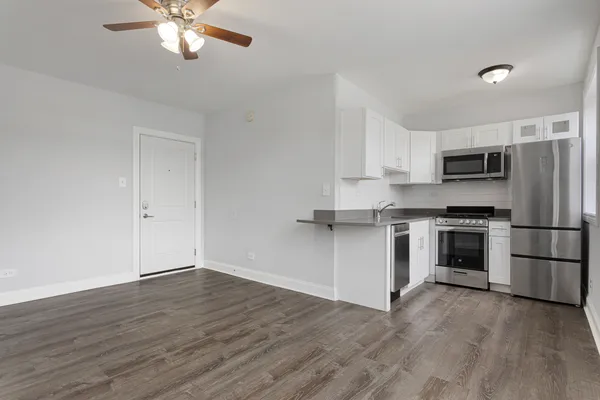 a kitchen with a refrigerator and a stove top oven