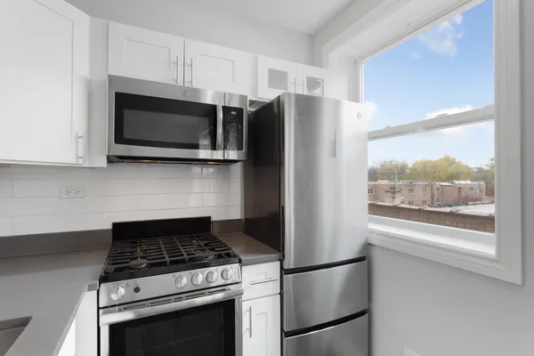 a kitchen with stainless steel appliances granite countertop a refrigerator stove top oven and sink