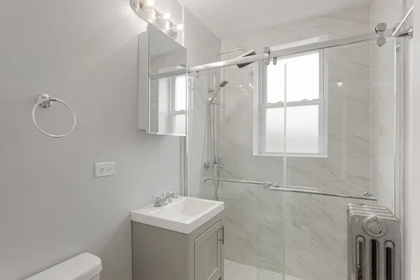 a bathroom with a sink a toilet and shower