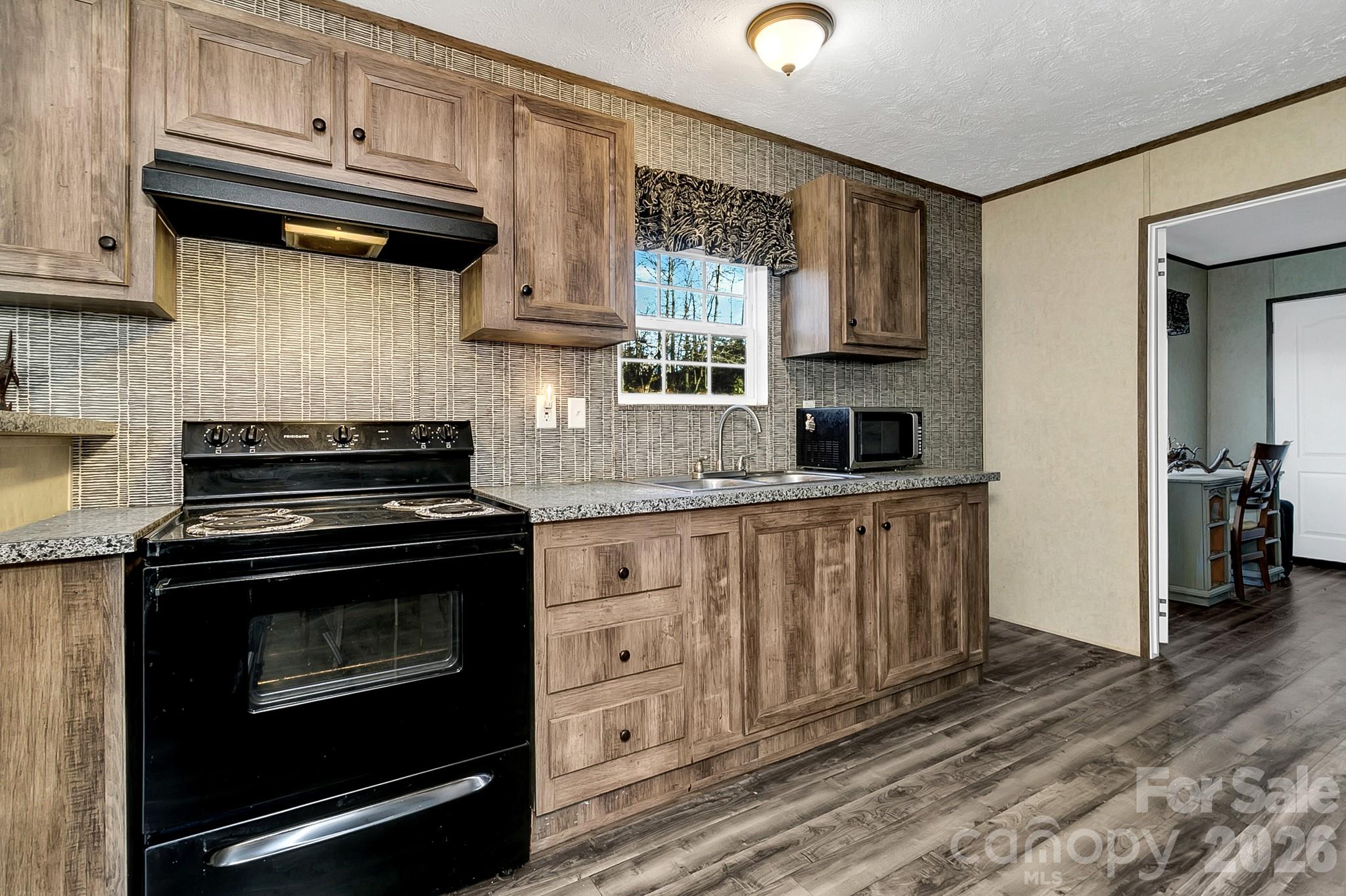 44 Tuttle Road Hendersonville, NC 28792 - Photo 35 of 37 a kitchen with granite countertop a stove sink and cabinets