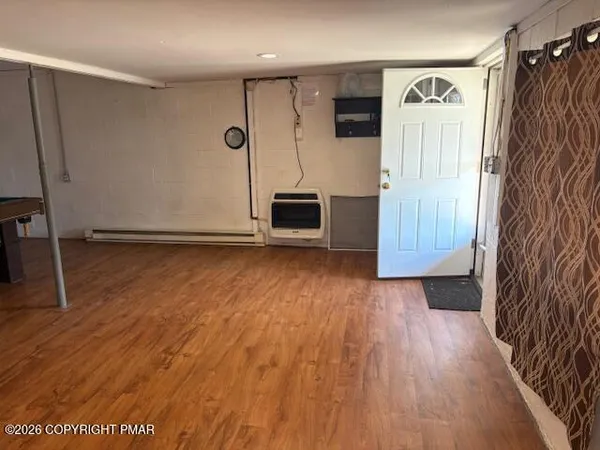 a view of a livingroom with wooden floor and a ceiling fan