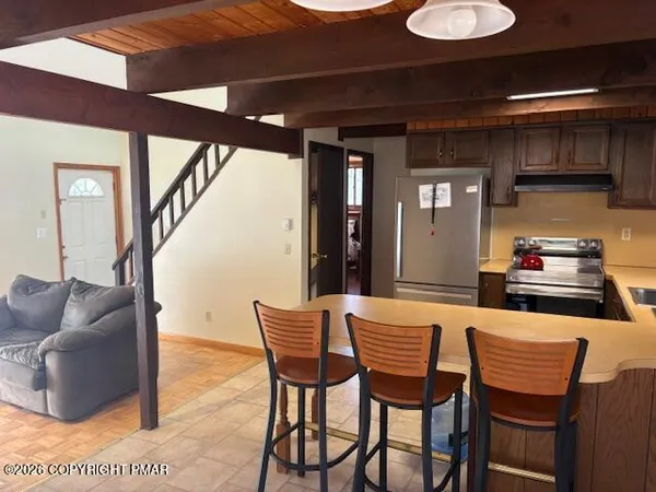 a dining room with furniture and a kitchen view