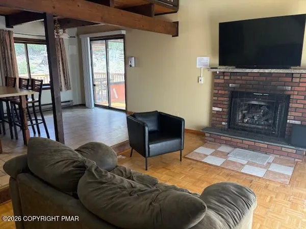 a living room with furniture a flat screen tv and a fireplace