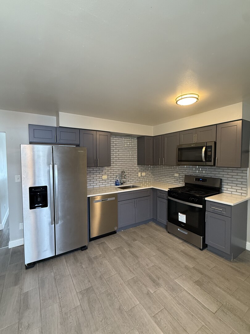 14421 South Ravinia Avenue, Unit 1S Orland Park, IL 60462 - Photo 2 of 9 a kitchen with stainless steel appliances a refrigerator and a stove top oven
