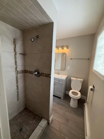 a white toilet sitting in a bathroom next to a sink