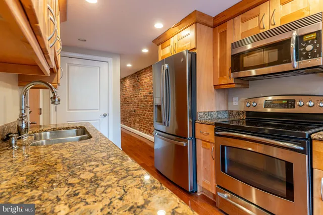 a kitchen with granite countertop a refrigerator stove and microwave