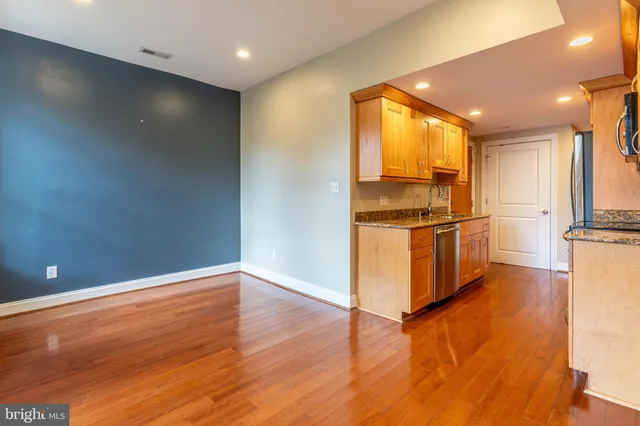 a view of kitchen with stainless steel appliances granite countertop a refrigerator and a stove top oven