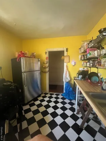 a kitchen with a sink a refrigerator and cabinets