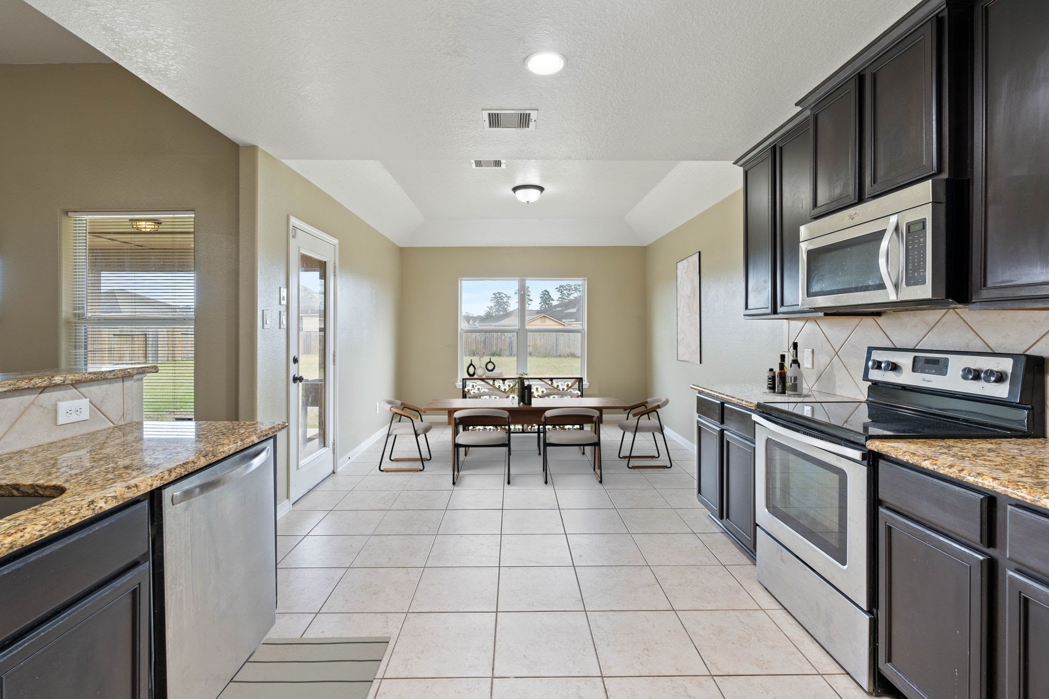 18875 Maverick Ranch Road East Magnolia, TX 77355 - Photo 8 of 45 a kitchen with stainless steel appliances granite countertop a stove a sink and a microwave