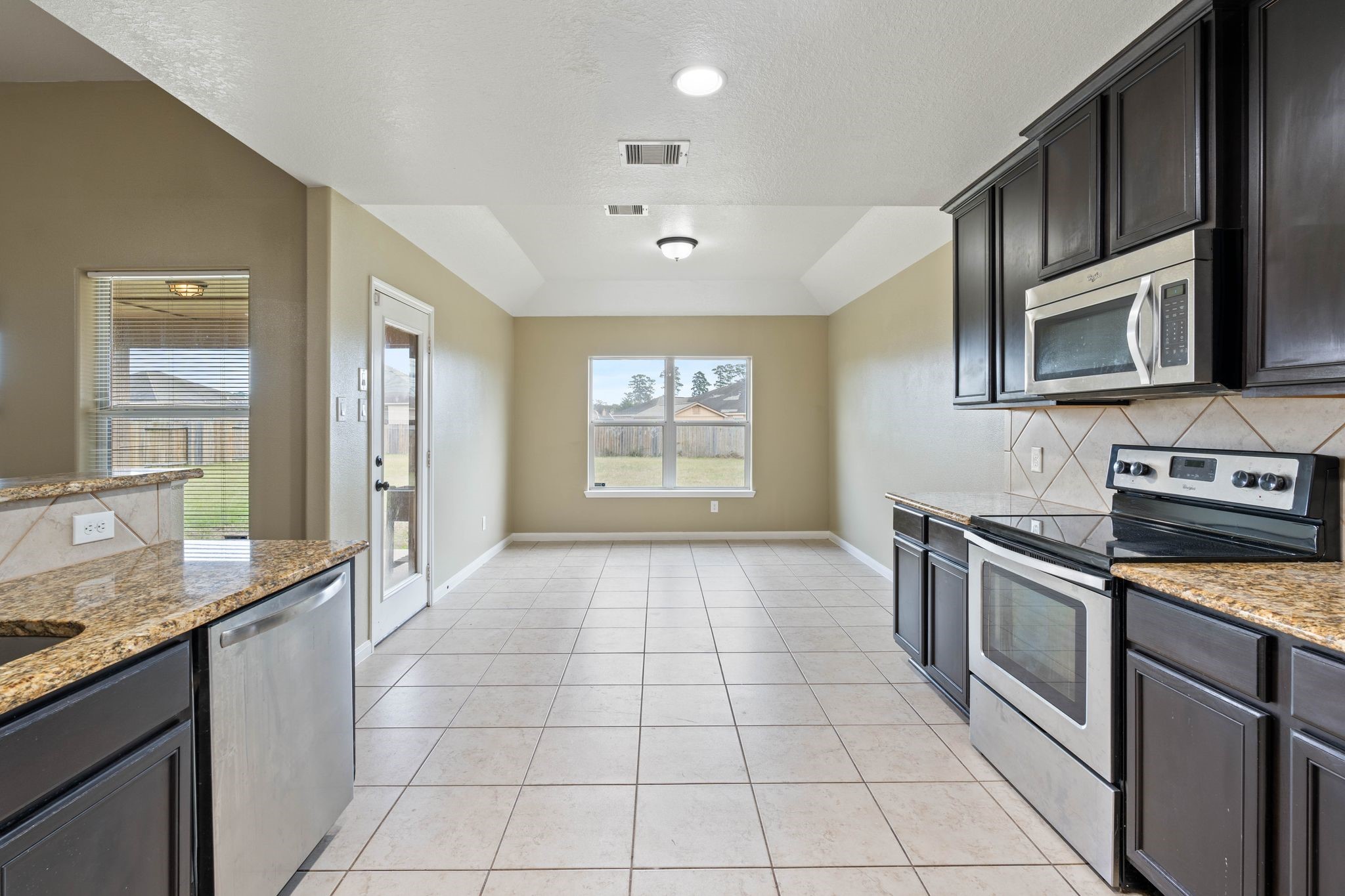 18875 Maverick Ranch Road East Magnolia, TX 77355 - Photo 9 of 45 a kitchen with stainless steel appliances granite countertop a stove a sink and a microwave
