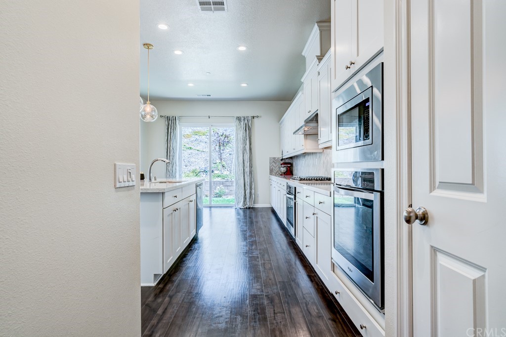 12370 Alamo Drive Rancho Cucamonga, CA 91739 - Photo 11 of 47 a kitchen with white cabinets and stainless steel appliances