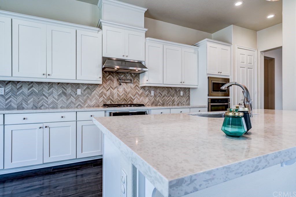 12370 Alamo Drive Rancho Cucamonga, CA 91739 - Photo 12 of 47 a kitchen with granite countertop a sink a stove and cabinets