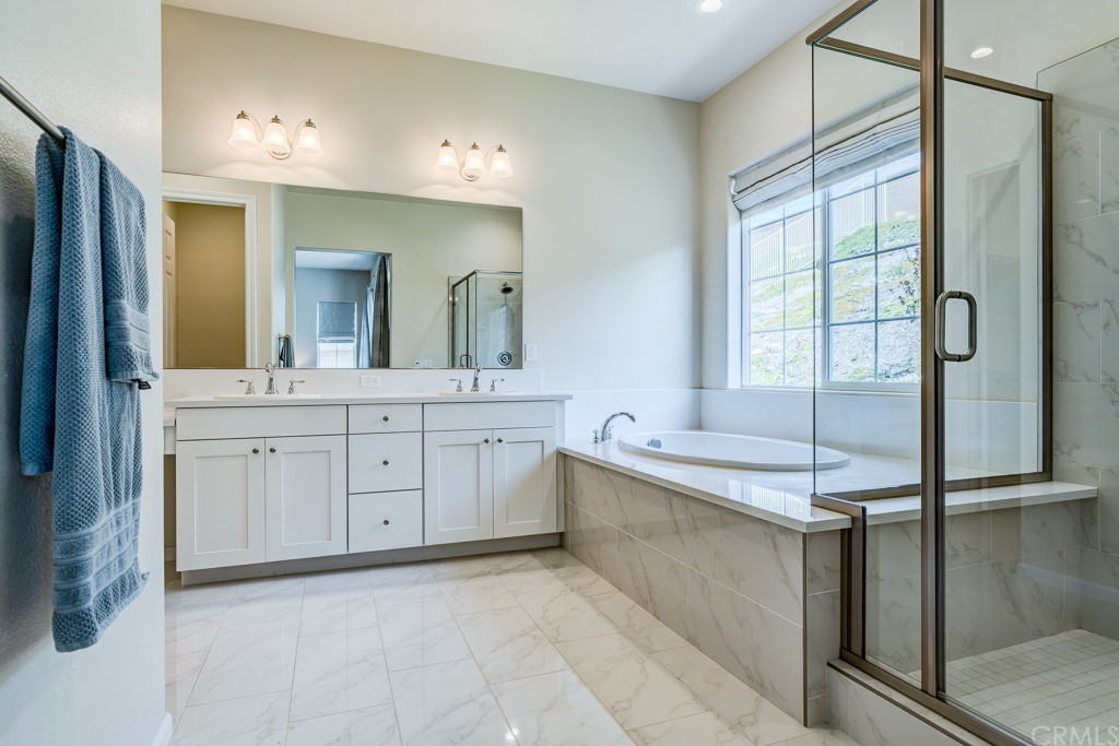 12370 Alamo Drive Rancho Cucamonga, CA 91739 - Photo 37 of 47 a spacious bathroom with a double vanity sink a mirror and a bathtub