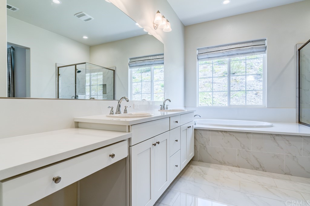 12370 Alamo Drive Rancho Cucamonga, CA 91739 - Photo 40 of 47 a bathroom with a tub sink and mirror