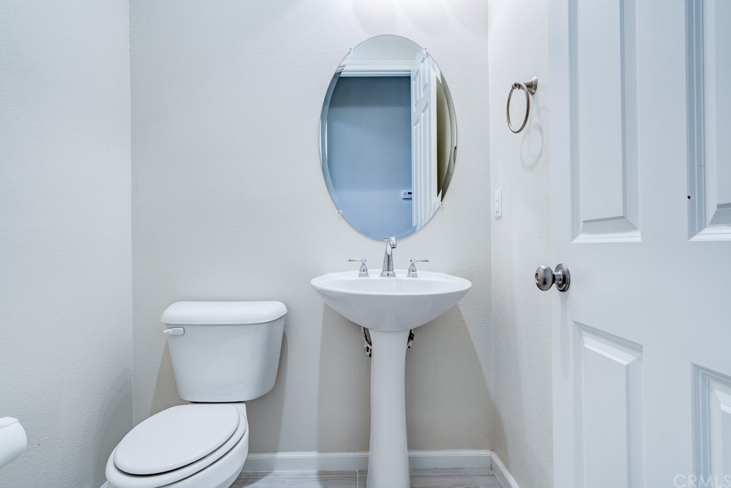 12370 Alamo Drive Rancho Cucamonga, CA 91739 - Photo 46 of 47 a bathroom with a toilet sink and mirror