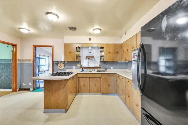 a large kitchen with a large counter top appliances and cabinets