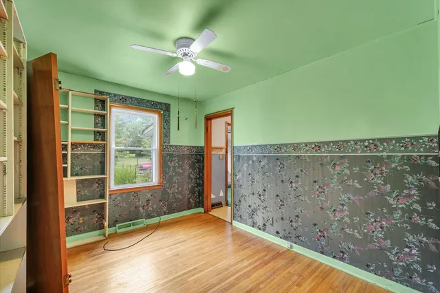 a view of a livingroom with wooden floor and a ceiling fan