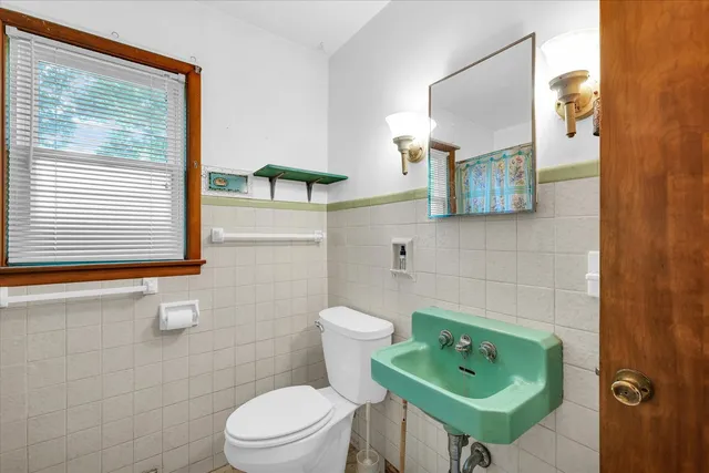 a bathroom with a toilet sink and mirror