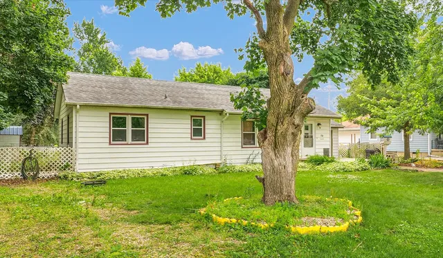 a backyard of a house with potted plants and large tree