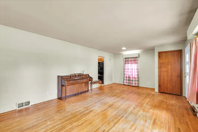 a view of an empty room with window and a wooden floor