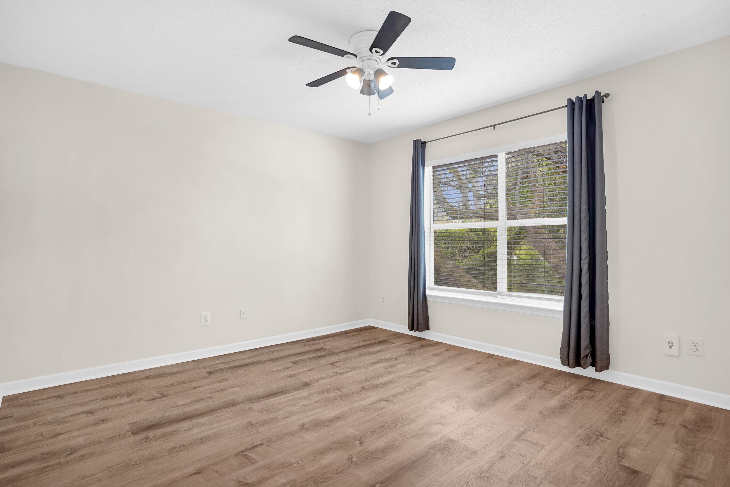 204 16th Street, Unit G St. Augustine Beach, FL 32080 - Photo 23 of 31 an empty room with wooden floor and windows