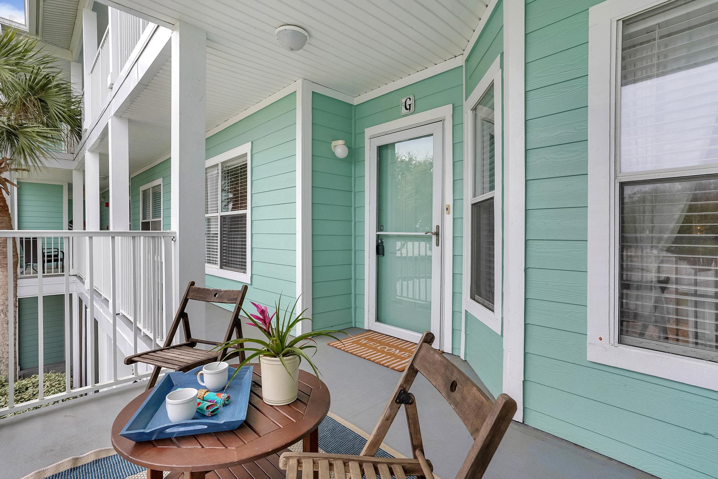 204 16th Street, Unit G St. Augustine Beach, FL 32080 - Photo 5 of 31 a view of a balcony that has two chairs and a potted plant