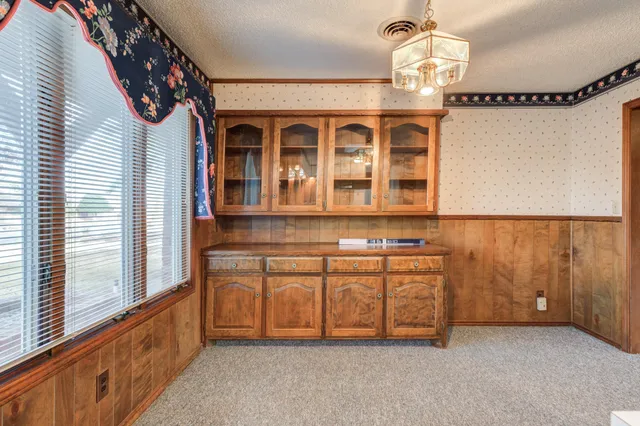 an empty room with windows and fireplace