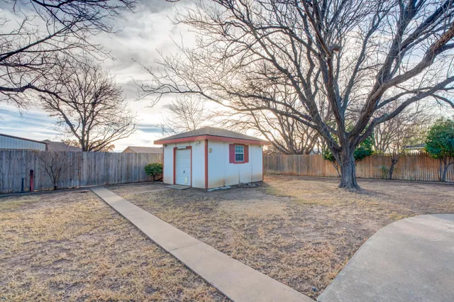 a front view of a house with a garden and trees